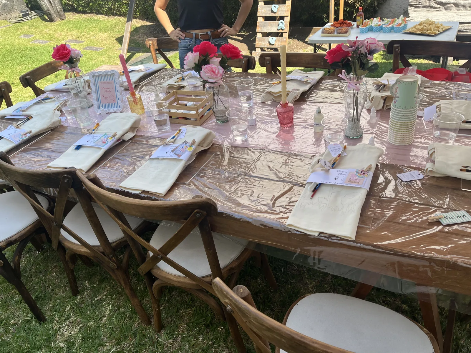 Mesa larga montada en un jardín para una celebración con taller de pintura