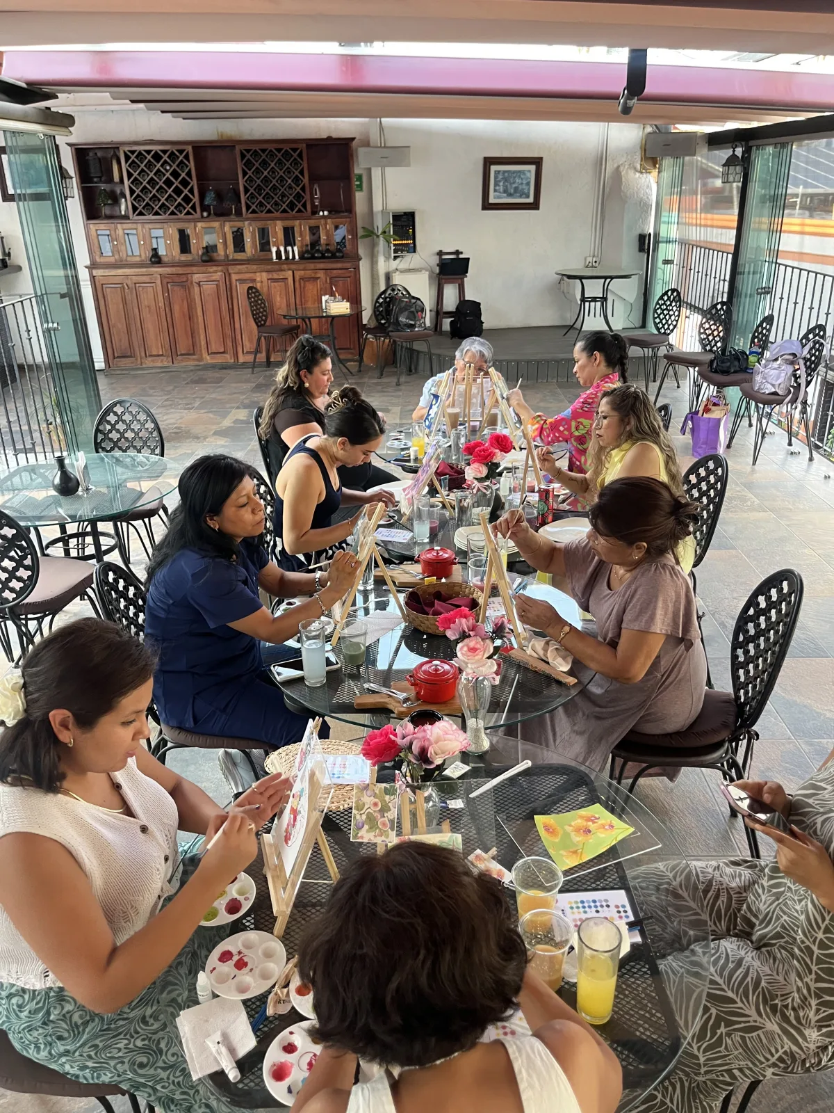 Grupo de asistentes pintando en una terraza durante un taller privado